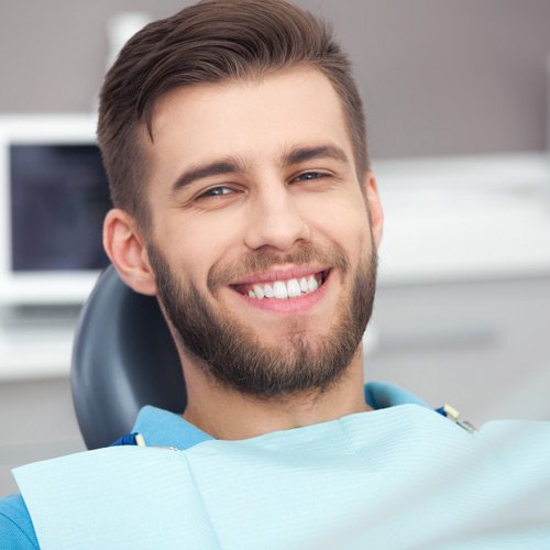 Man sitting in dental chair smiling.
