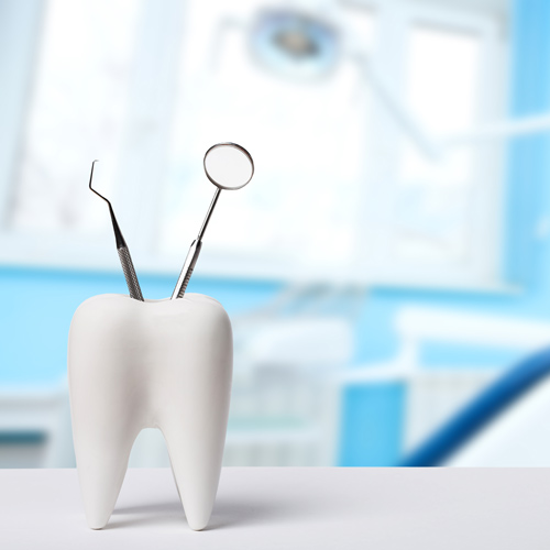 Dental tools in tooth-shaped holder.
