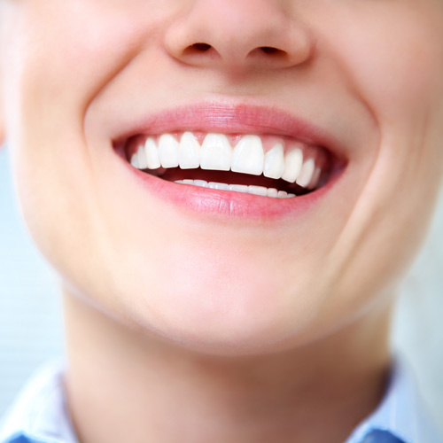 Close up of smiling mouth with straight white teeth.