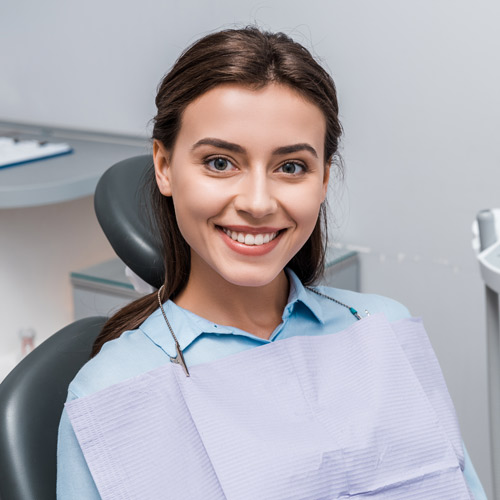 Patient smiling and sitting in dental chair.